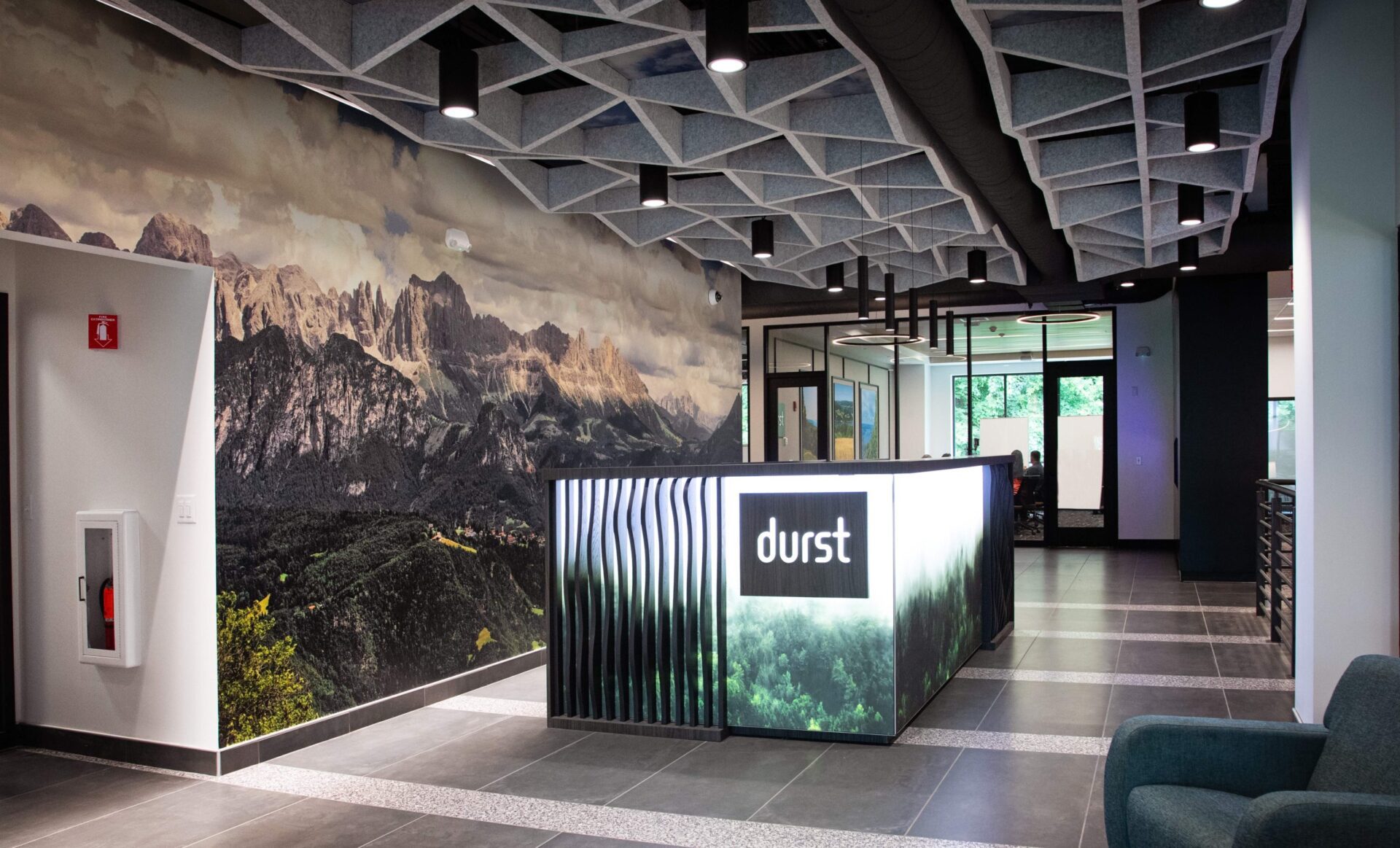 Modern office lobby with a mountain mural wall and a desk labeled durst